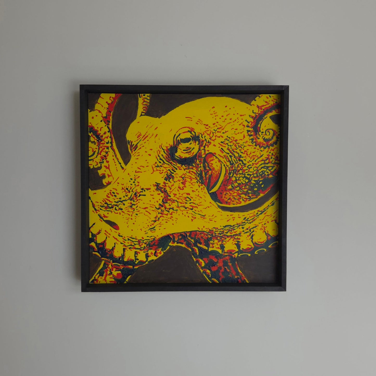 Red, Yellow and Blue painting of an octopus, hanging on a neutral wall.
