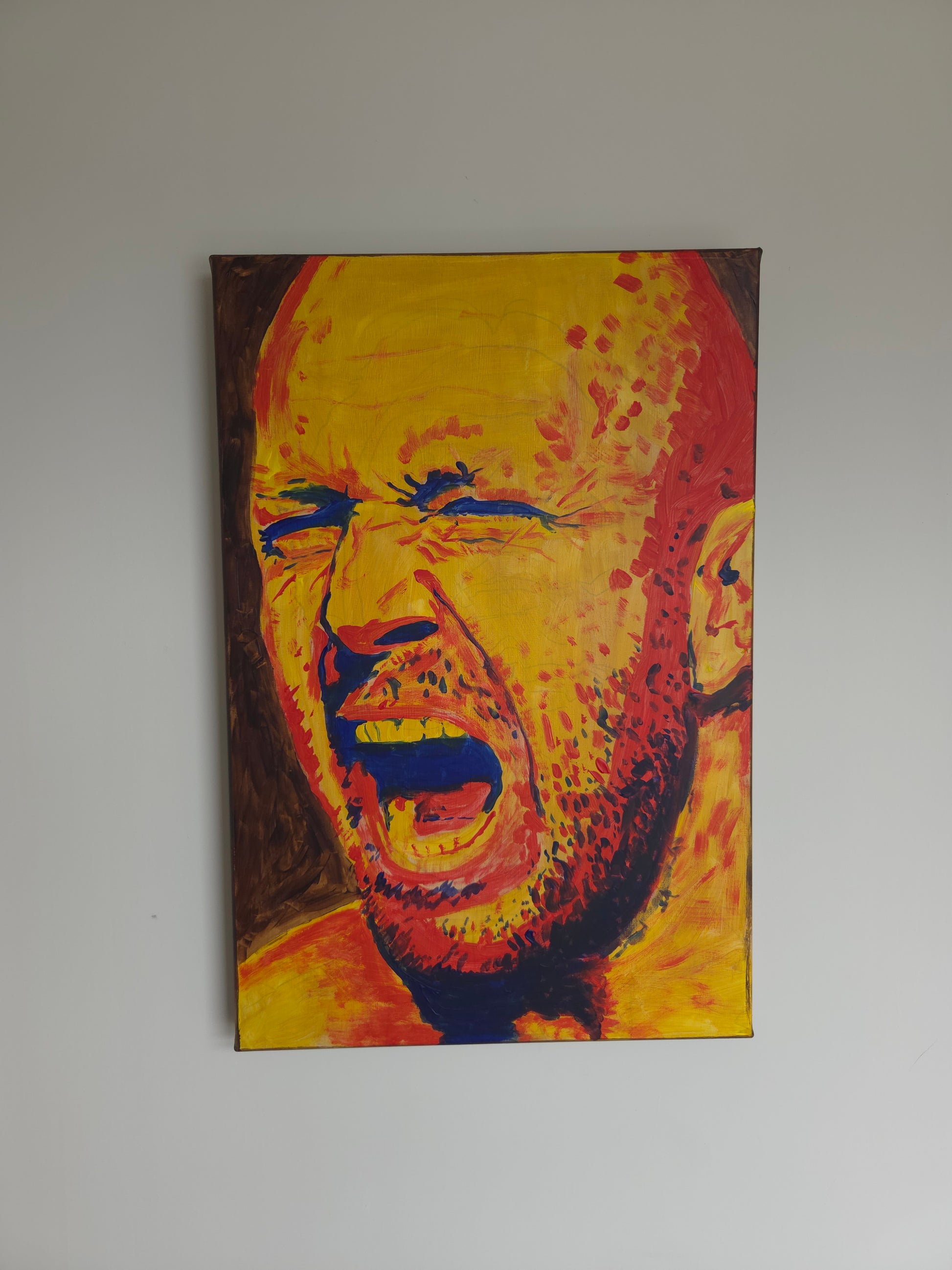A hand-painted expressionist portrait titled "Printer Jam" on a vertical canvas. The painting features a bald man with a beard, his eyes tightly shut and mouth wide open in a visceral scream. The color palette is dominated by bright yellow skin tones with intense red and orange highlights and deep blue shadows used for the eyes, mouth, and beard details. The background is a flat, earthy brown.